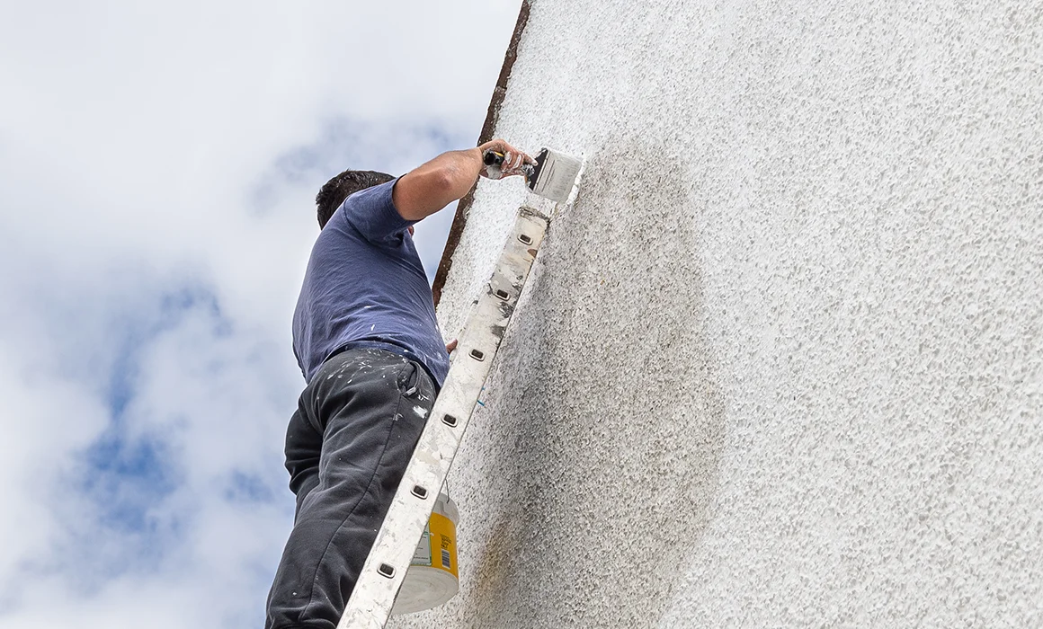 Peintre professionnel entrain de peindre au rouleau